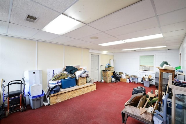 basement with a paneled ceiling and carpet