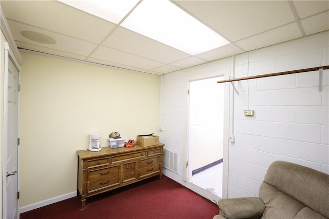 living area with a drop ceiling