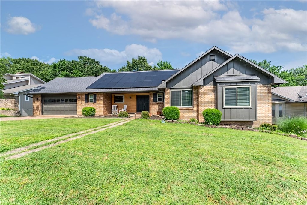 ranch-style house featuring concrete driveway, board and batten siding, an attached garage, and a front yard