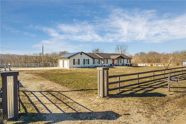 view of gate featuring solar panels and a yard