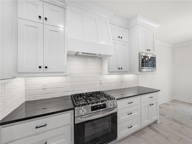 kitchen featuring light hardwood / wood-style flooring, stainless steel appliances, crown molding, backsplash, and white cabinetry