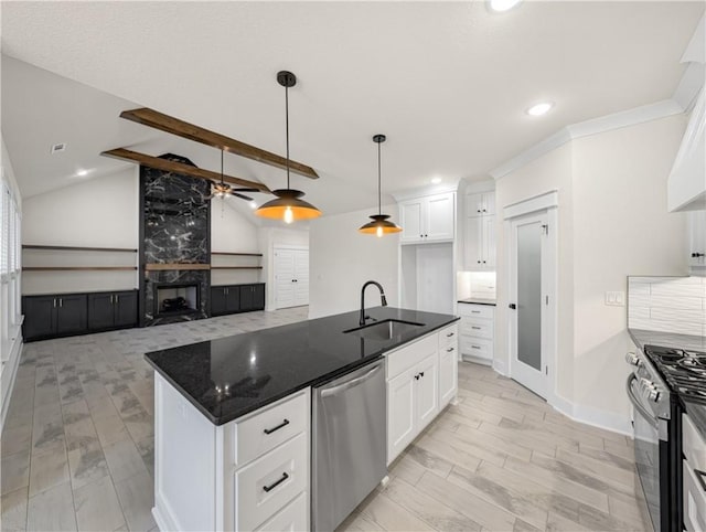 kitchen featuring white cabinetry, appliances with stainless steel finishes, sink, and dark stone counters