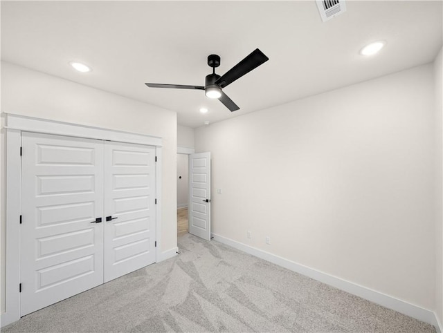 unfurnished bedroom with light carpet, ceiling fan, and a closet