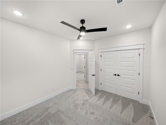 unfurnished bedroom featuring light carpet, ceiling fan, and a closet