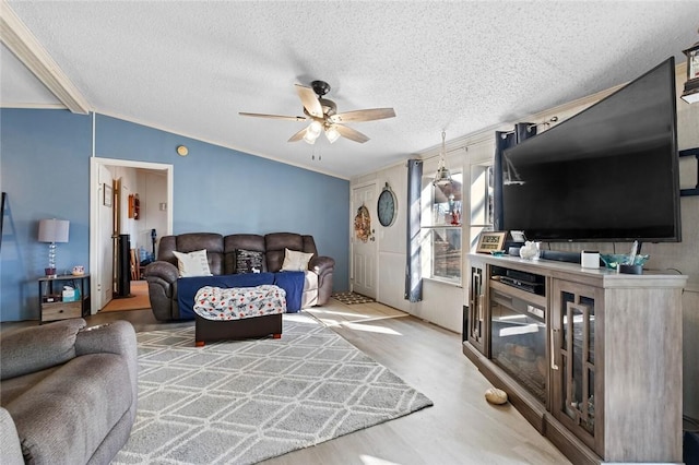 living room with a textured ceiling, ceiling fan, light hardwood / wood-style floors, and lofted ceiling