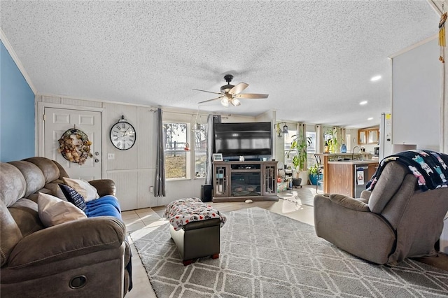 living room with ceiling fan, sink, a healthy amount of sunlight, and a textured ceiling