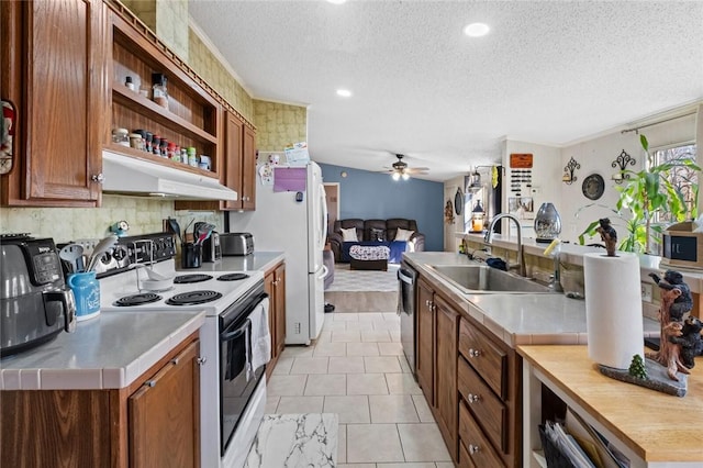 kitchen featuring ceiling fan, sink, stainless steel appliances, and a textured ceiling