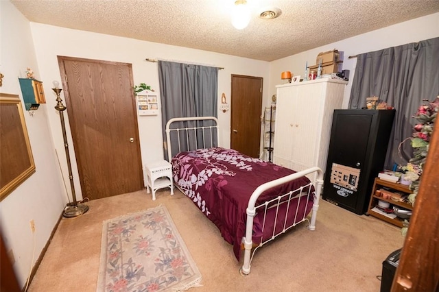 bedroom featuring a textured ceiling and light colored carpet