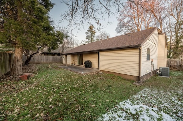 view of side of home featuring a yard, a patio, and central air condition unit