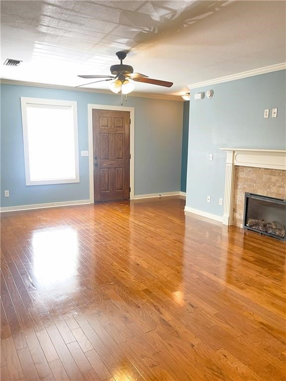 unfurnished living room with hardwood / wood-style floors, ceiling fan, ornamental molding, and a tile fireplace