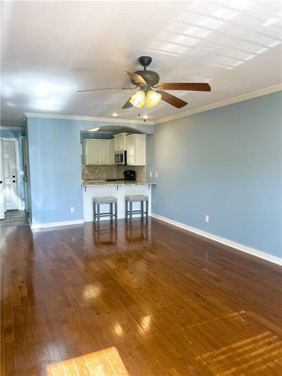 interior space featuring crown molding, dark hardwood / wood-style flooring, and ceiling fan