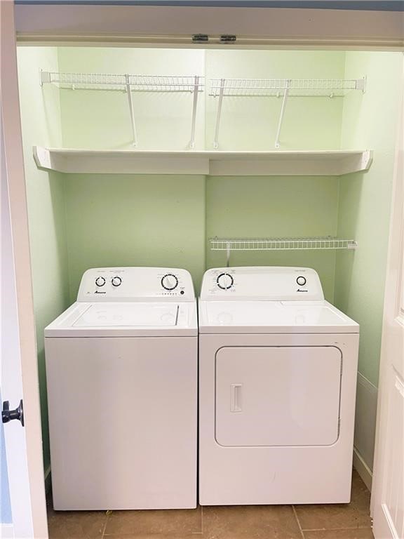 clothes washing area with tile patterned floors and washing machine and dryer