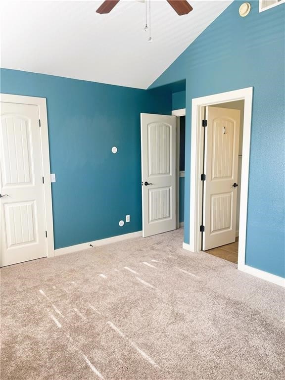 unfurnished bedroom featuring ceiling fan, light colored carpet, and lofted ceiling