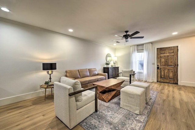 living room featuring ceiling fan, light hardwood / wood-style floors, and ornamental molding