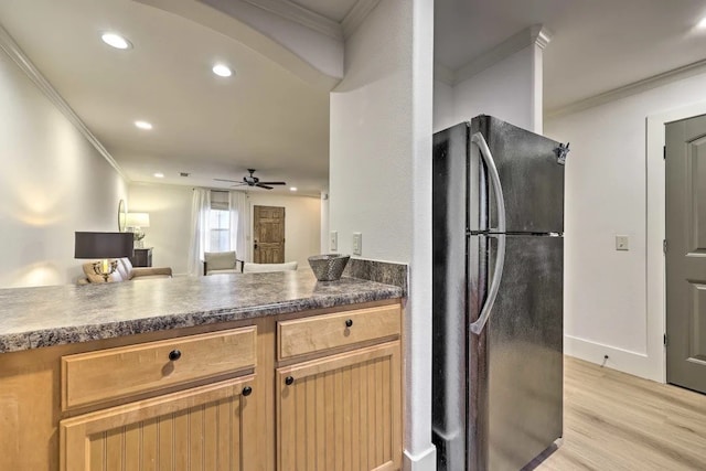 kitchen featuring light hardwood / wood-style flooring, black fridge, ceiling fan, and crown molding