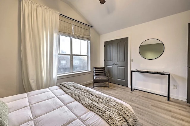 bedroom featuring ceiling fan, a closet, lofted ceiling, and light hardwood / wood-style flooring