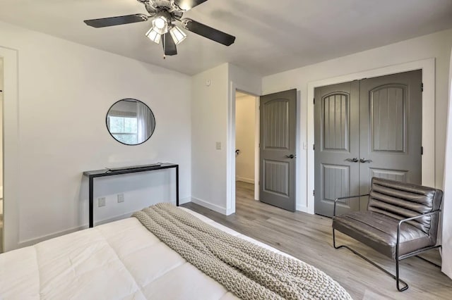 bedroom featuring ceiling fan, light wood-type flooring, and a closet