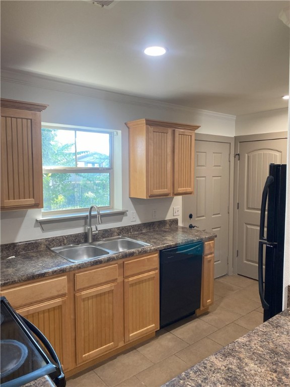 kitchen featuring crown molding, sink, light tile patterned floors, and black appliances