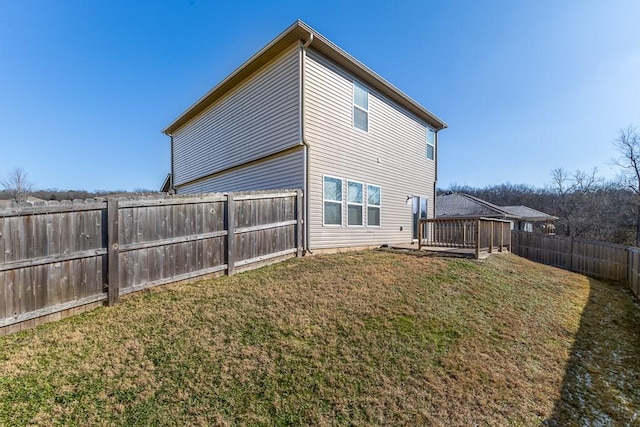 back of property with a yard and a deck