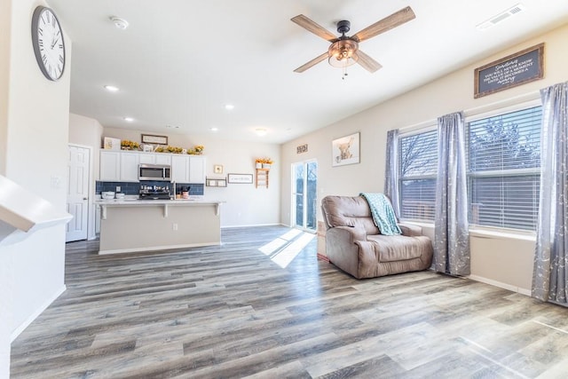 living room featuring ceiling fan, a healthy amount of sunlight, and light wood-type flooring