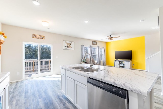 kitchen with white cabinetry, sink, stainless steel dishwasher, a center island with sink, and light wood-type flooring