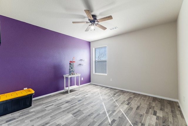 unfurnished room with light wood-type flooring and ceiling fan