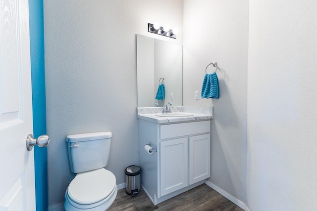 bathroom with hardwood / wood-style floors, vanity, and toilet