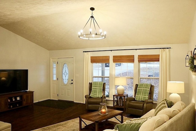 living room featuring dark hardwood / wood-style floors, lofted ceiling, and a chandelier