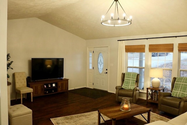 living room featuring hardwood / wood-style flooring, lofted ceiling, and a chandelier