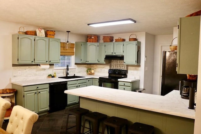 kitchen featuring kitchen peninsula, sink, green cabinets, and black appliances