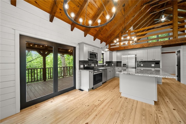 kitchen with beam ceiling, light stone countertops, stainless steel appliances, high vaulted ceiling, and wooden ceiling