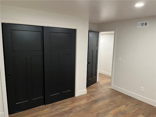 unfurnished bedroom featuring hardwood / wood-style flooring and a closet