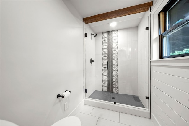 bathroom featuring tile patterned floors, a shower with door, and beam ceiling