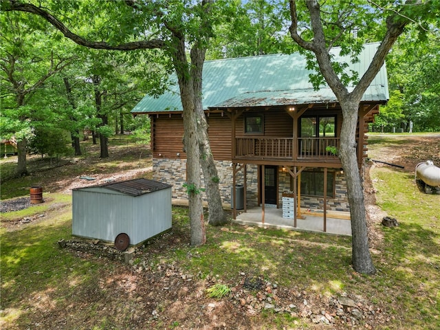 back of property featuring a wooden deck, a yard, and a patio