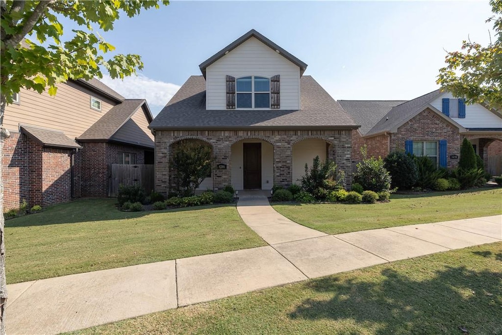 view of front of house featuring covered porch and a front lawn