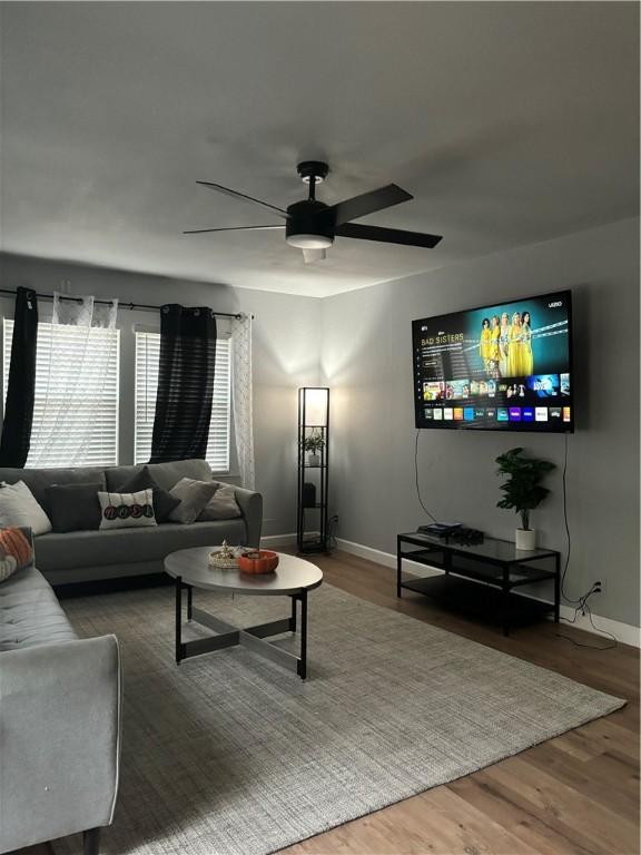 living room featuring hardwood / wood-style floors and ceiling fan