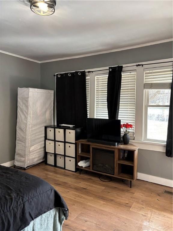 bedroom with crown molding and light hardwood / wood-style flooring