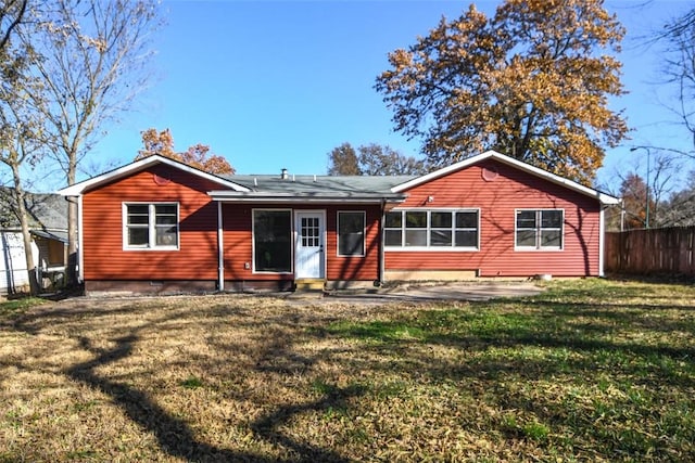 rear view of house featuring a lawn and a patio area