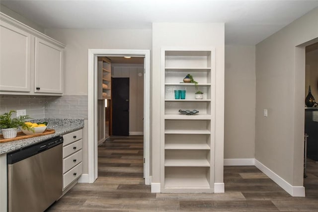 kitchen with stainless steel dishwasher, decorative backsplash, light stone countertops, dark hardwood / wood-style flooring, and white cabinetry