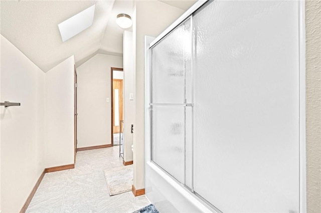 bathroom featuring enclosed tub / shower combo and lofted ceiling with skylight