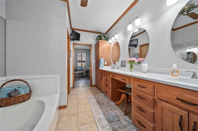 bathroom featuring a tub, vanity, crown molding, and tile patterned flooring