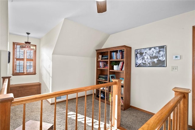 hallway with vaulted ceiling and carpet floors