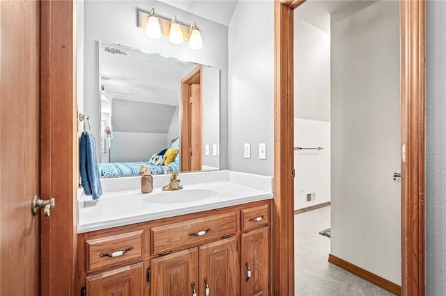 bathroom with lofted ceiling, tile patterned floors, and vanity