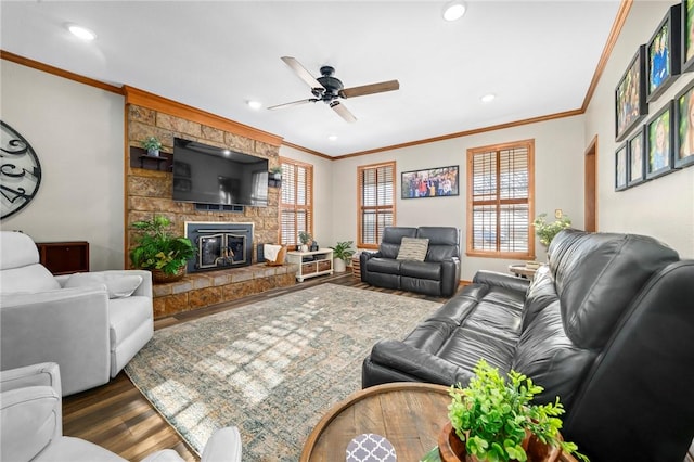 living room with ceiling fan, ornamental molding, a fireplace, and hardwood / wood-style flooring