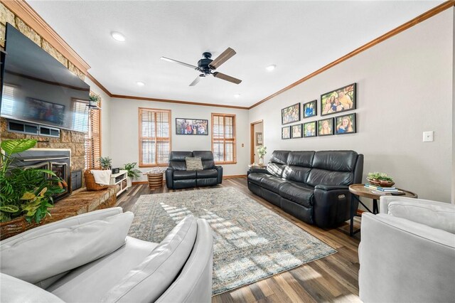 living room with ceiling fan, hardwood / wood-style floors, ornamental molding, and a fireplace