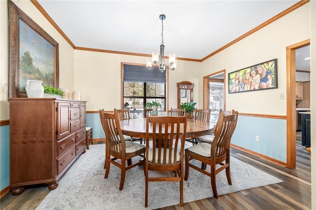 dining room featuring hardwood / wood-style flooring, crown molding, and a notable chandelier