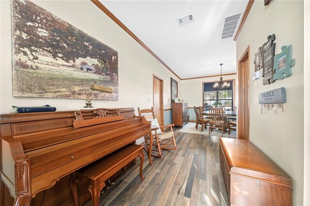 misc room with dark hardwood / wood-style floors, ornamental molding, and a chandelier