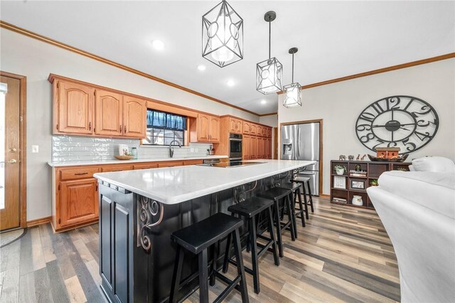 kitchen with black electric stovetop, a center island, a kitchen bar, dark wood-type flooring, and stainless steel fridge