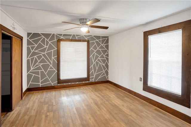 unfurnished room with a wealth of natural light, light hardwood / wood-style flooring, and ceiling fan