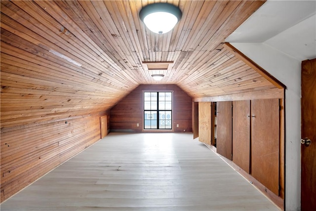 additional living space featuring lofted ceiling with skylight, wooden ceiling, and wood walls